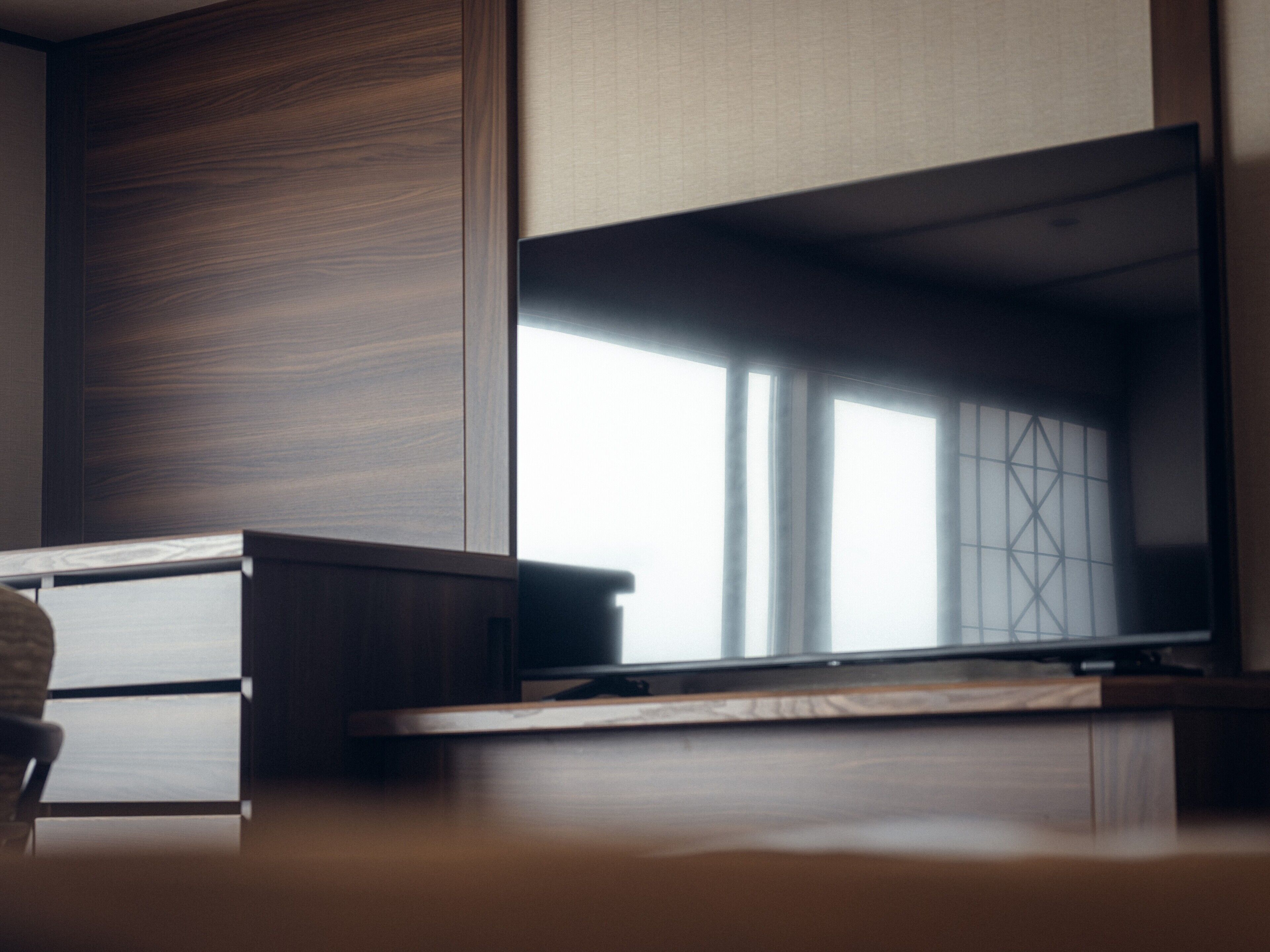 Ein modernes Zimmer mit einem Holztisch, einem Stuhl und einem großen Fenster mit Blick.