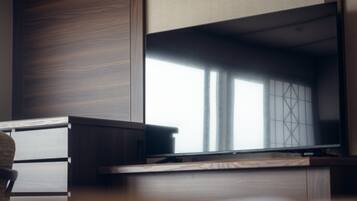 Una habitación moderna con un escritorio de madera, una silla y un amplio ventanal con vistas.