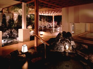 A serene indoor garden with a wooden walkway, stone features, and a lantern. - Hanabishi Hotel (Hakodate)