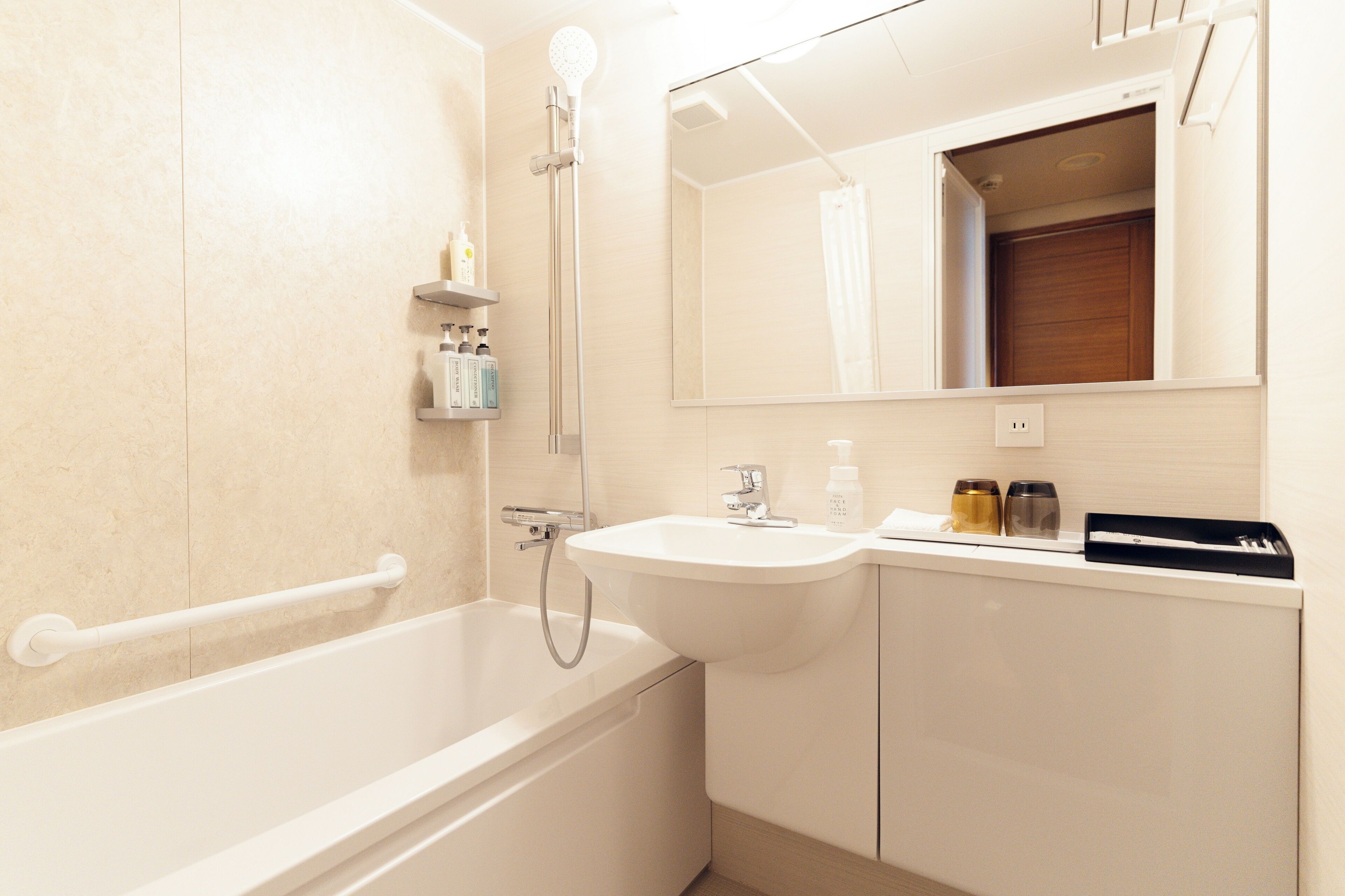A modern bathroom with a bathtub, sink, and mirror.