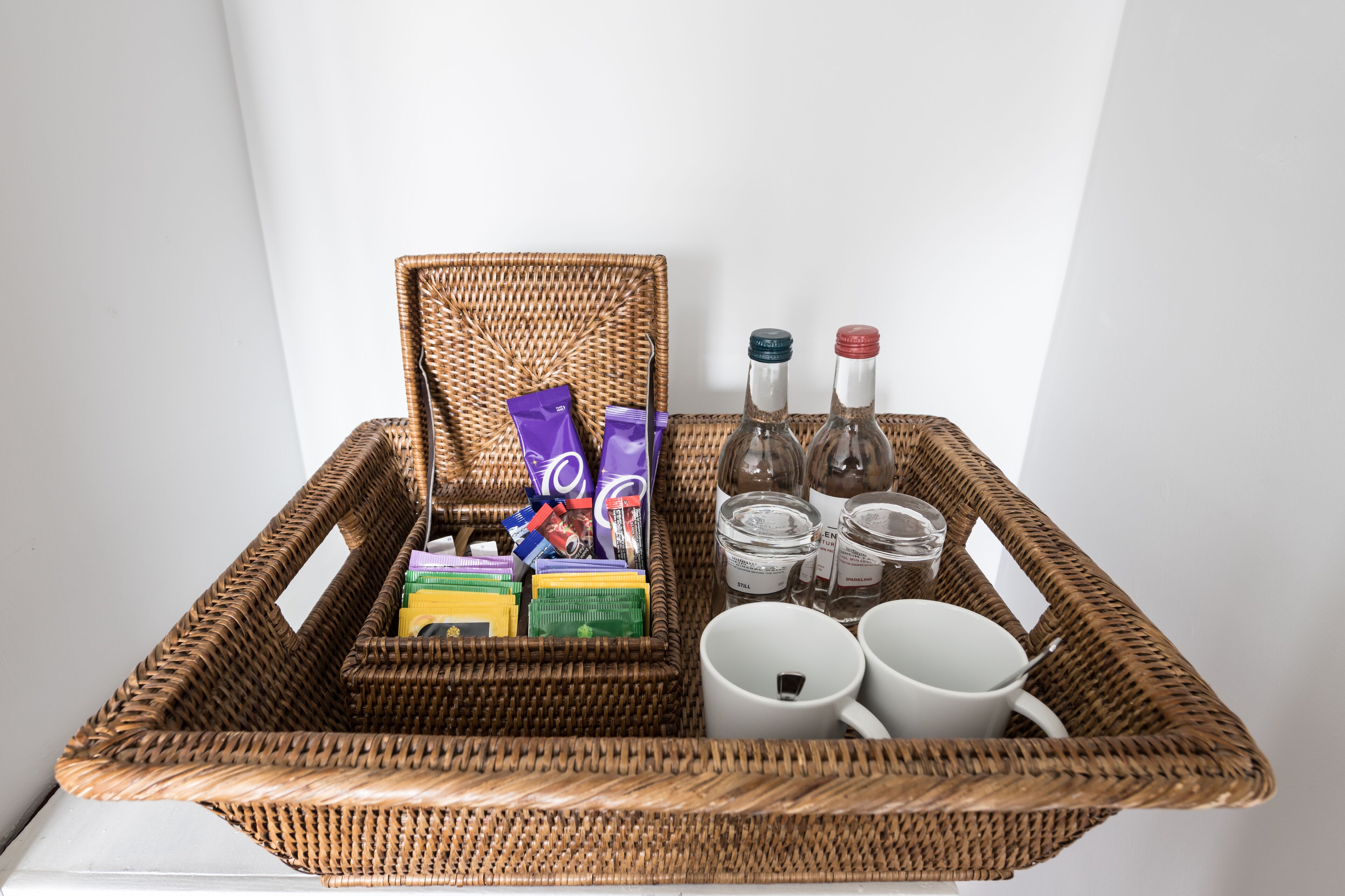 A wicker basket containing toiletries and a white mug.