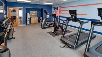 A gym with treadmills, elliptical machines, and free weights.
