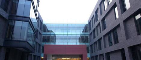 A modern hotel with a glass facade and a red entrance.