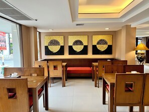 Ein Restaurant mit Holztischen und roten Sitzgelegenheiten.