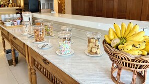 A buffet setup with various food items and a wicker basket of bananas. - Mariya Boutique Residence at Suvarnabhumi Airport (Bangkok)