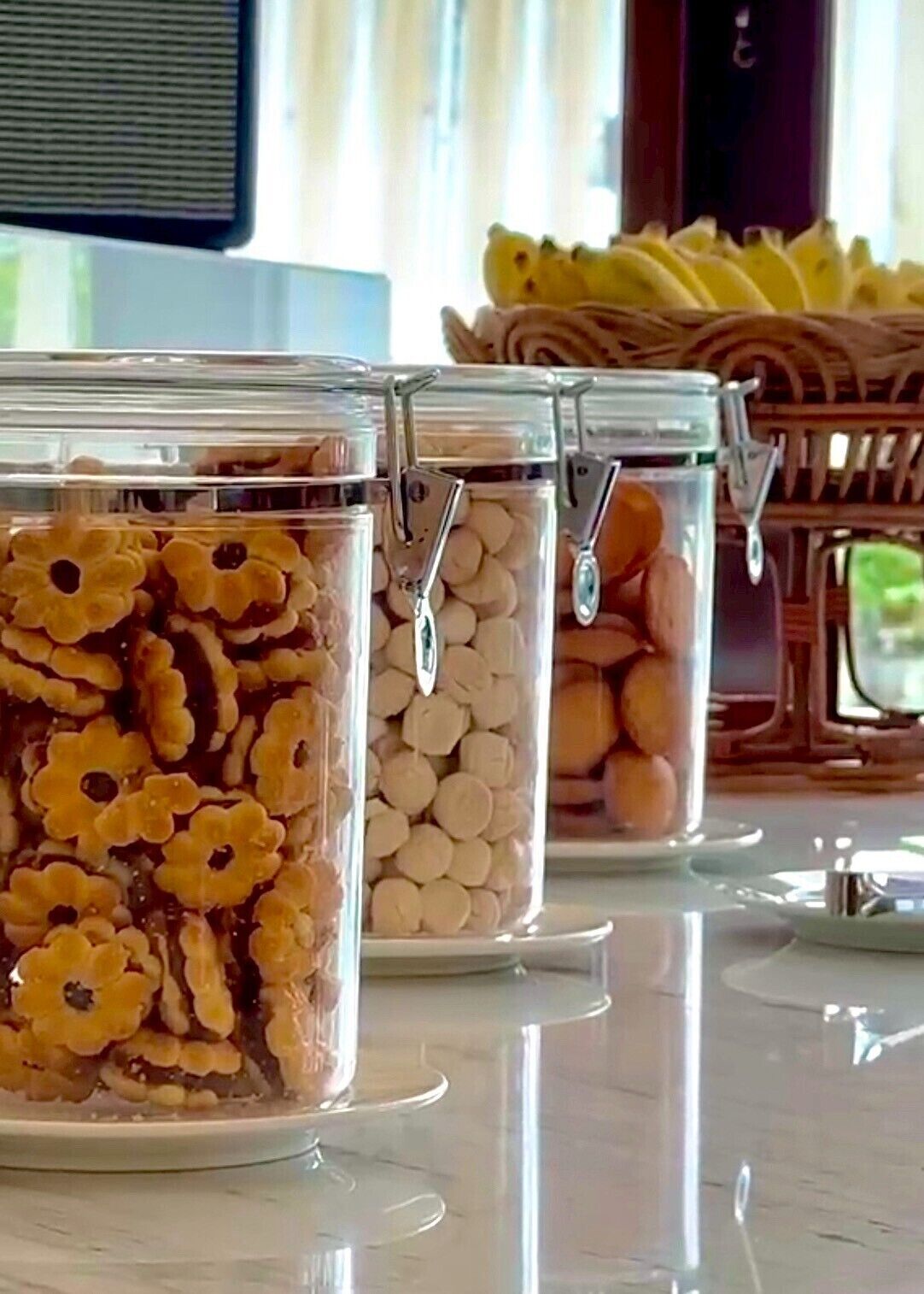 Trois récipients en verre munis de fermoirs métalliques, chacun contenant différents types de biscuits.