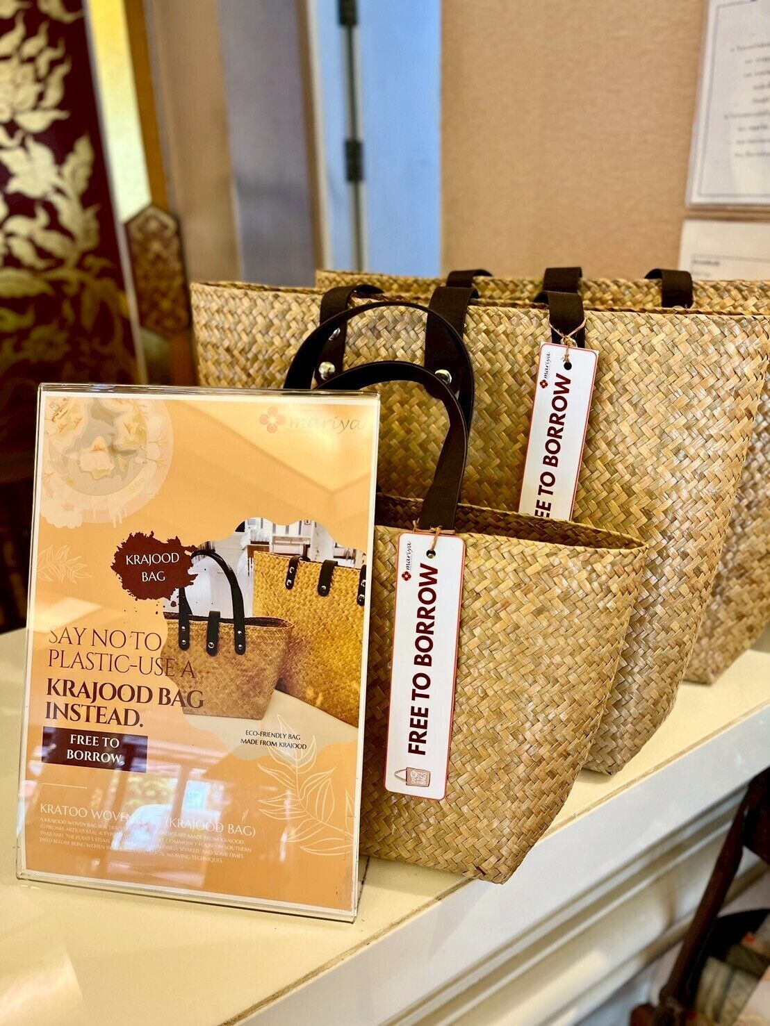 A display of woven bags with tags indicating they are free to borrow.