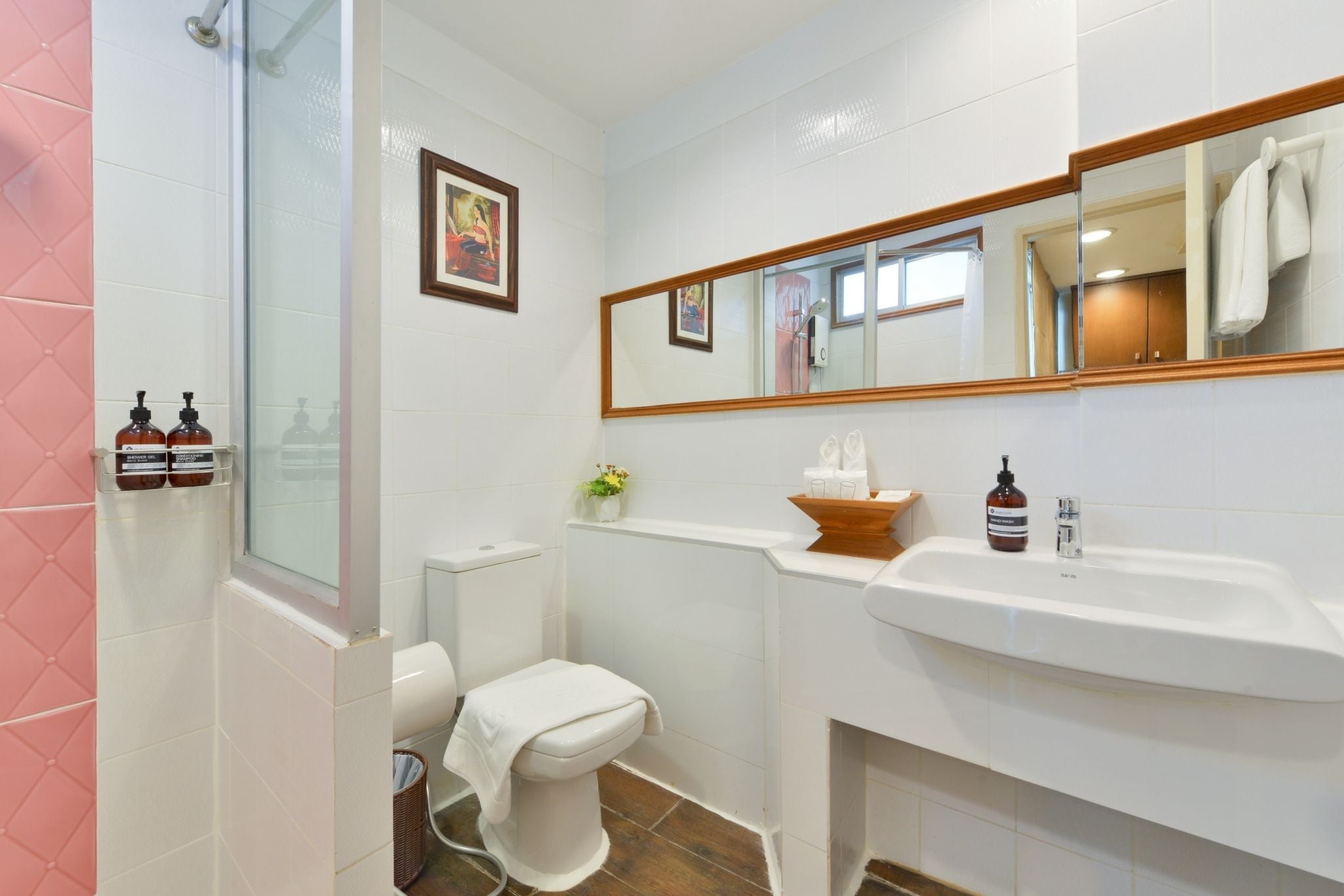 A bathroom with a toilet, sink, and shower area.
