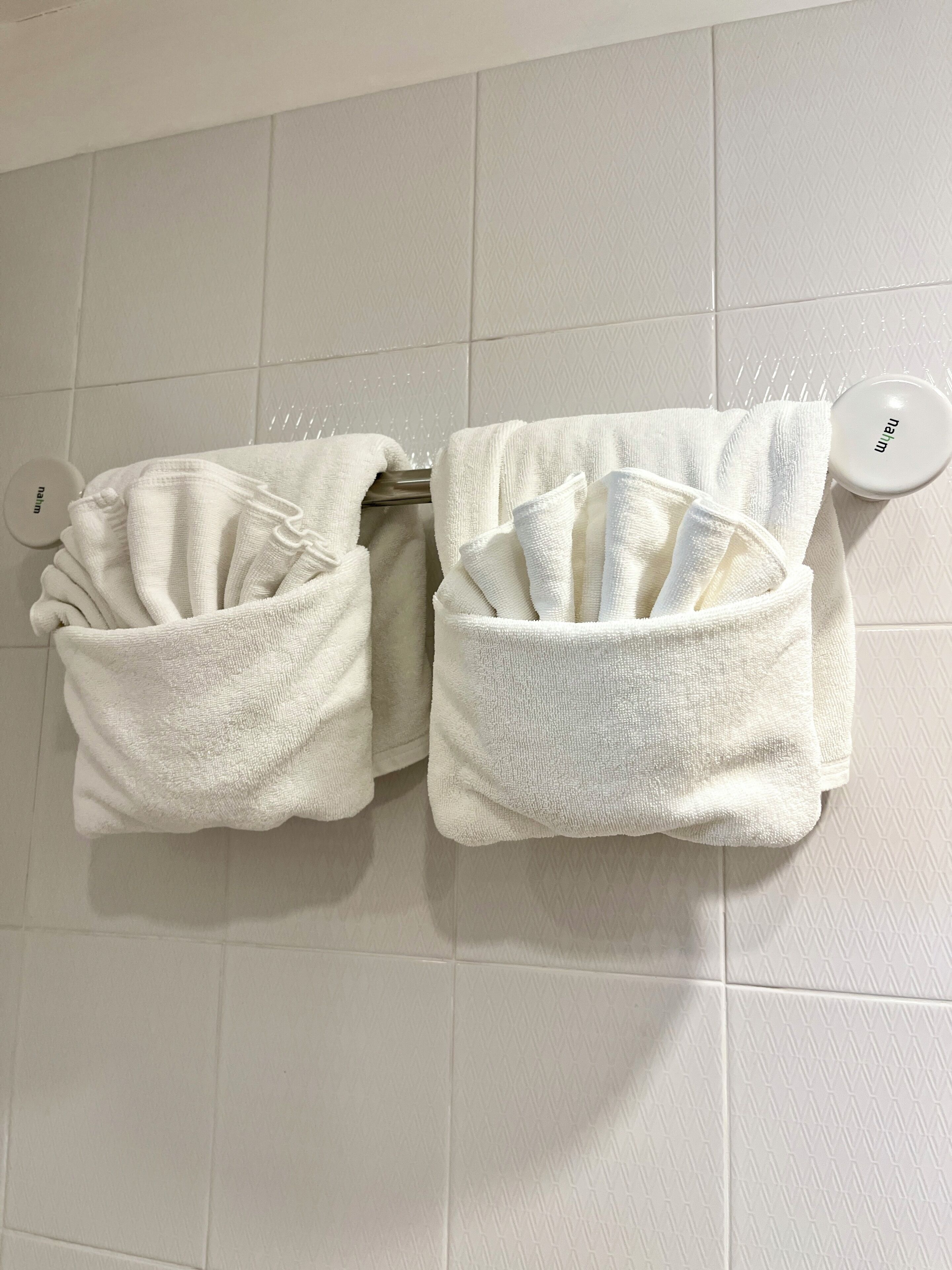 Two white towel racks with towels folded in them.