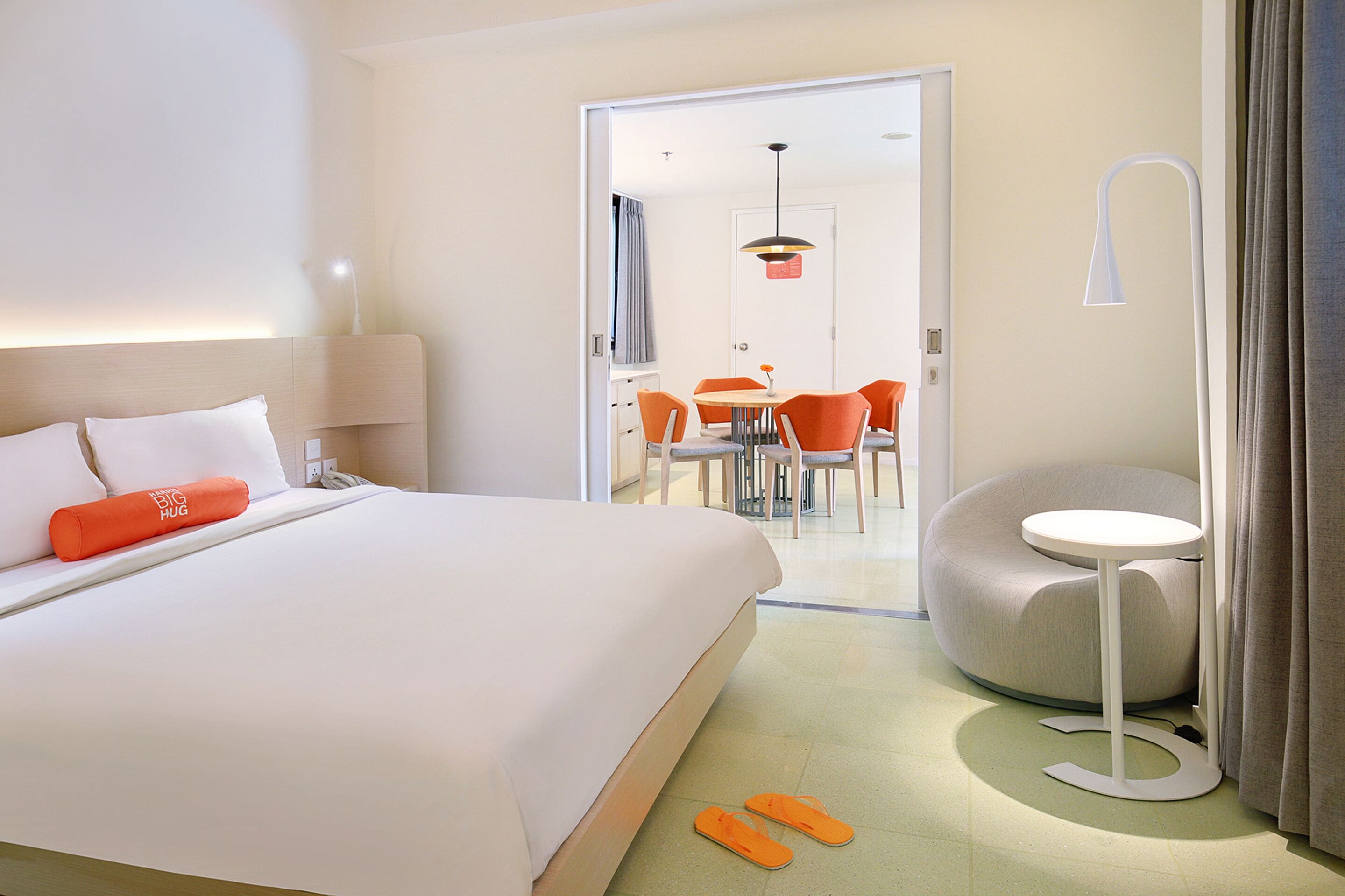 Habitación de hotel con una cama grande, una mesita redonda y una silla.