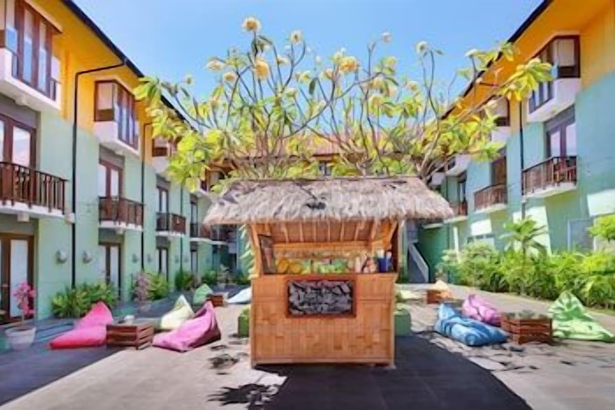 Een hotel binnenplaats met een houten constructie in het midden, balkons en begroening.