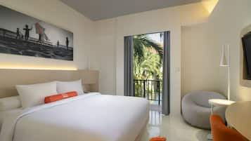 A modern hotel room with a large bed, a small round table, a chair, a TV, and a balcony with a view of palm trees.