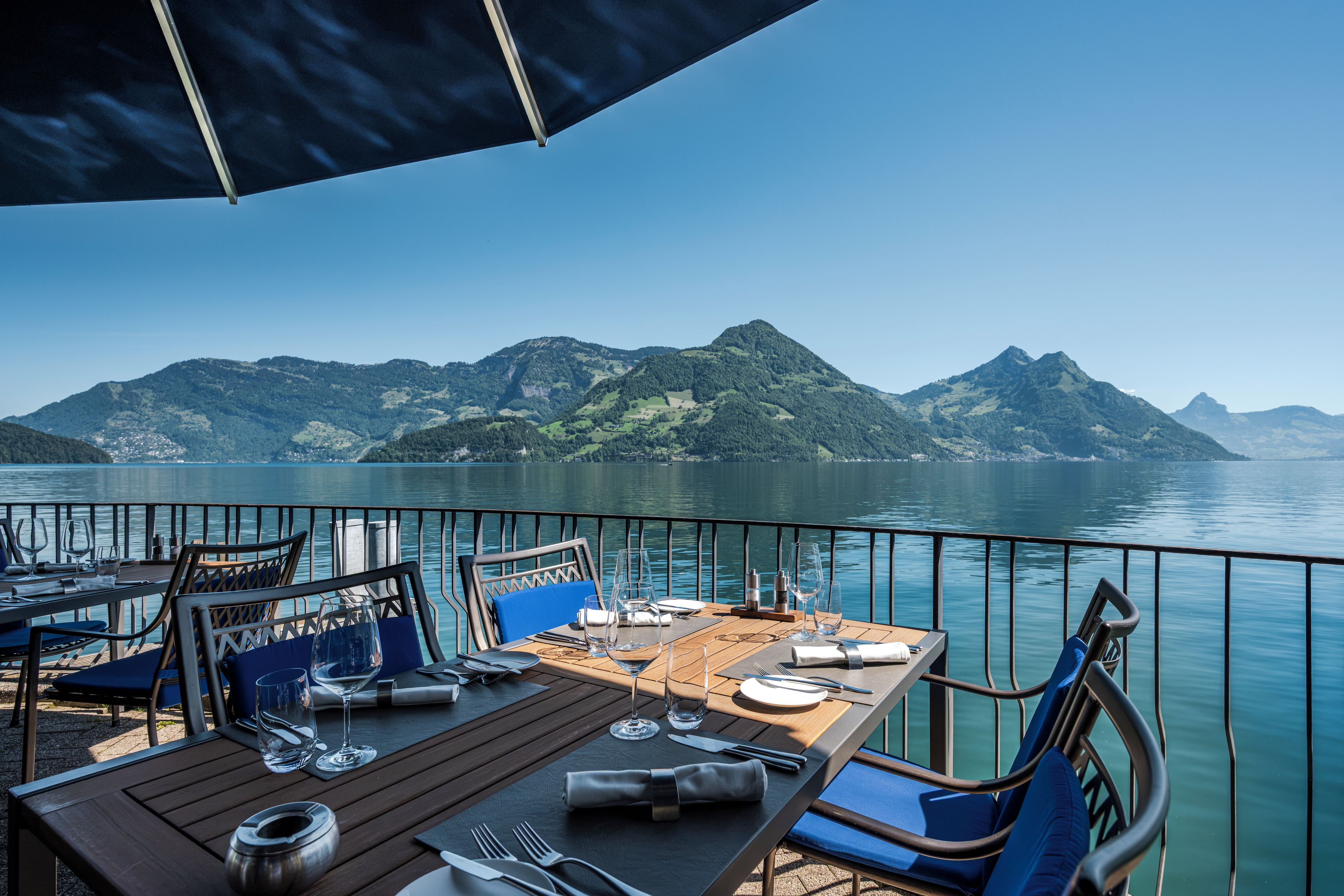 Mesa lista para comer con vistas a montañas y un lago.