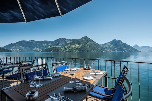 A table set for dining with a view of mountains and a lake. - Hotel Nidwaldnerhof direkt am See Swiss Quality (Beckenried)