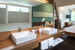 Un baño moderno con dos lavamanos, un espejo grande y un mueble de tocador de madera.