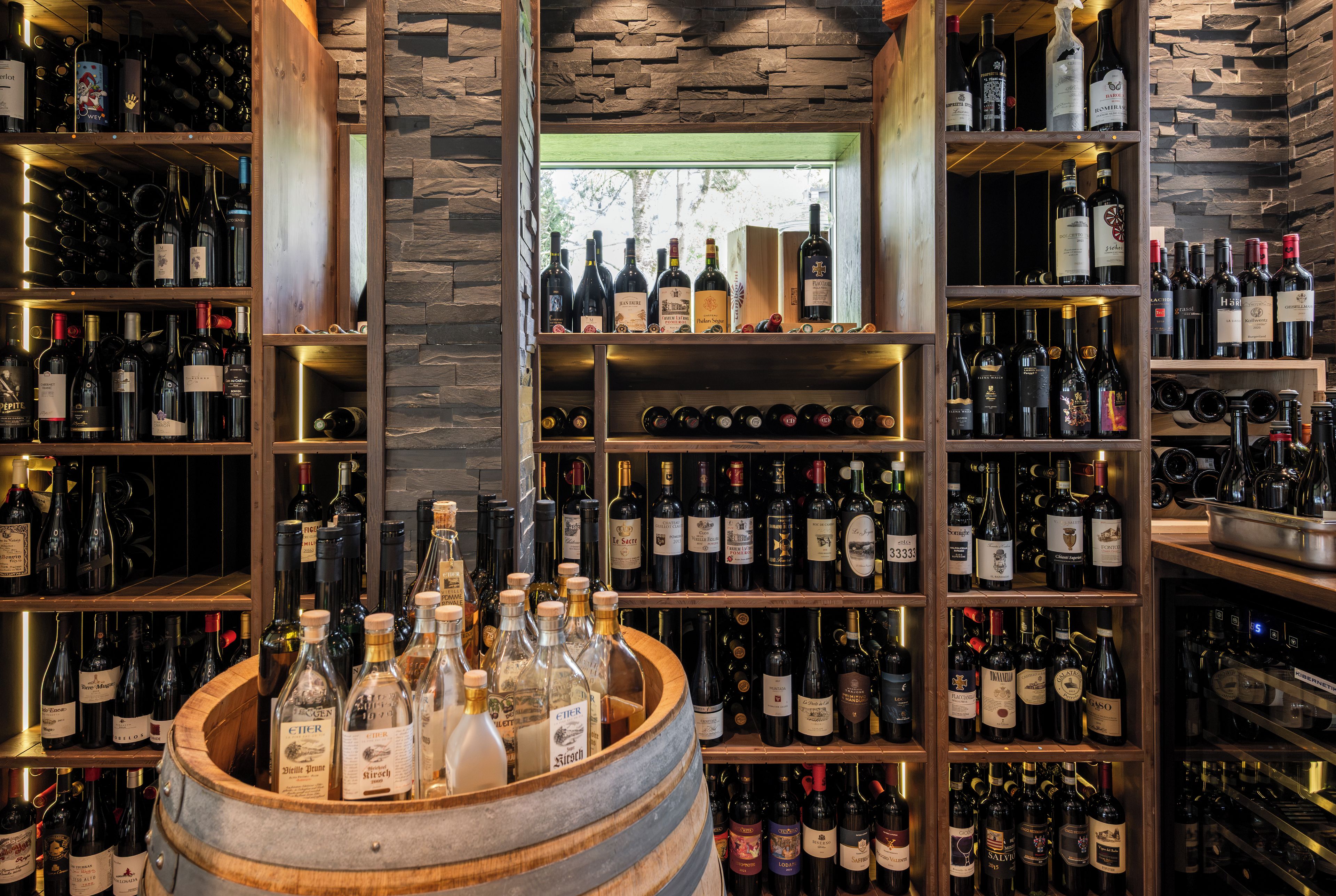 Une cave à vin avec des étagères en bois et un tonneau rempli de bouteilles.