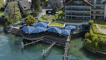 Un restaurant situé au bord de la rivière, avec une terrasse et un quai.