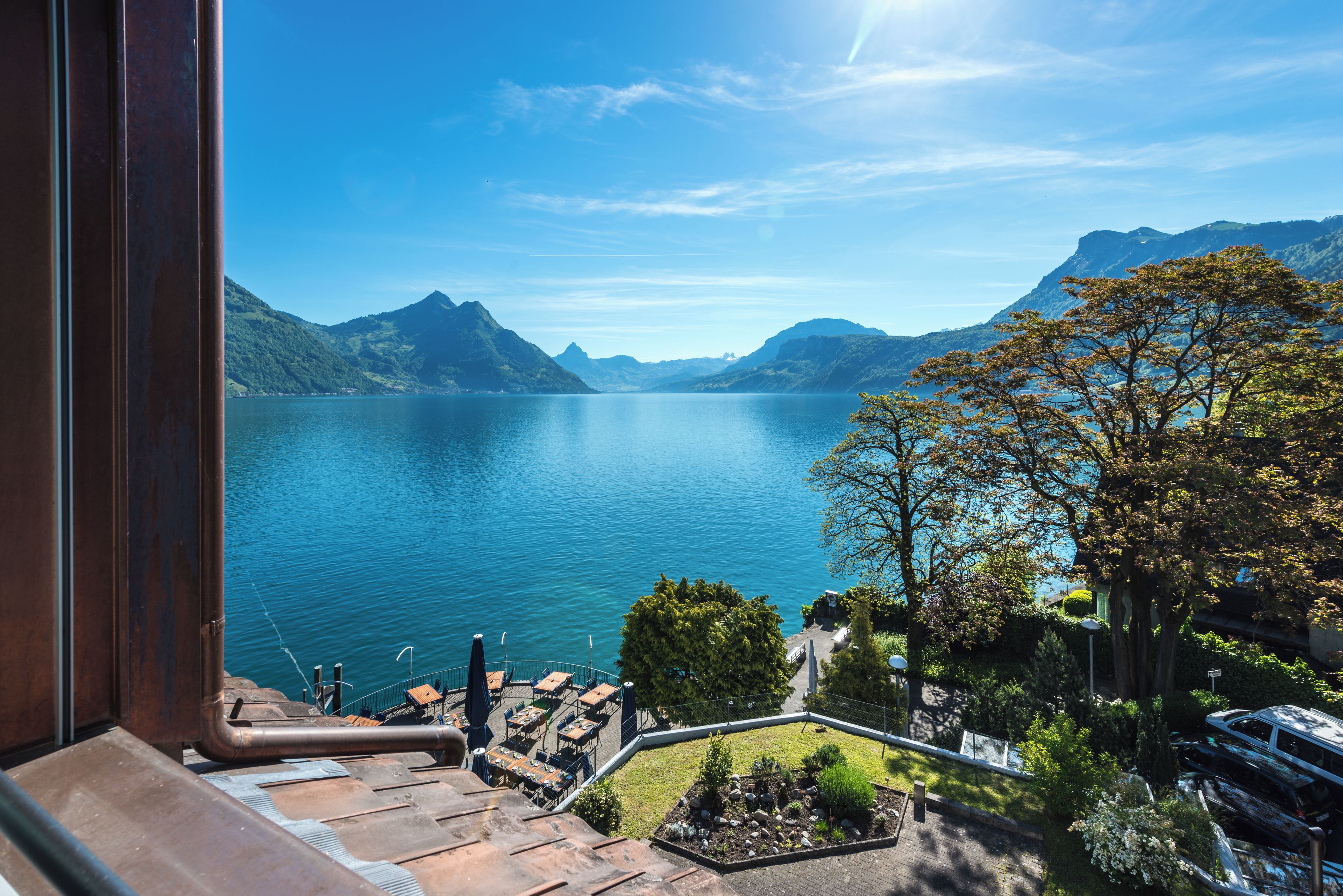 Een terras met uitzicht op een meer en bergen.