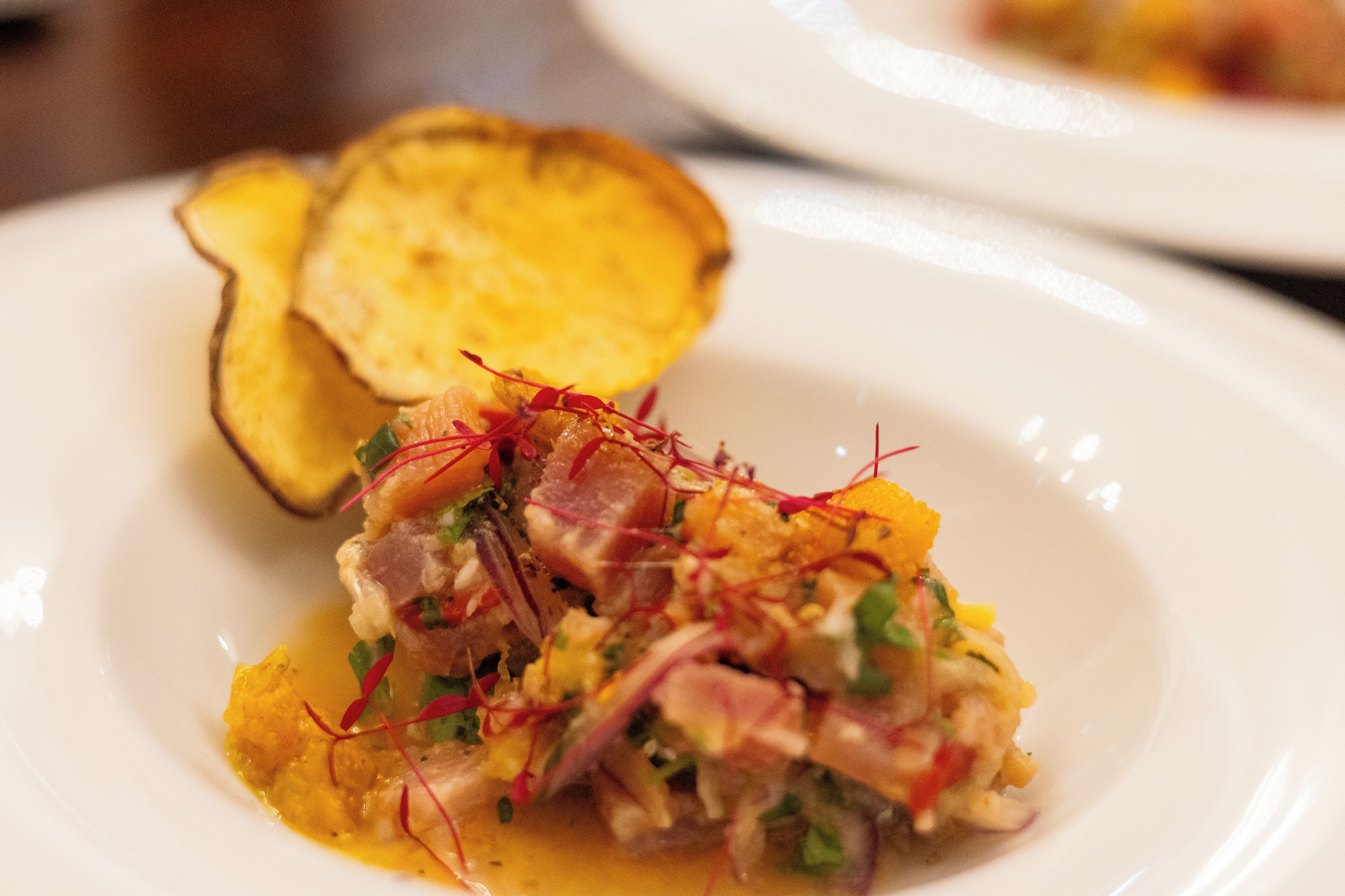 Une assiette de nourriture comprenant une portion de viande et des légumes, accompagnée d’un morceau de pomme de terre.