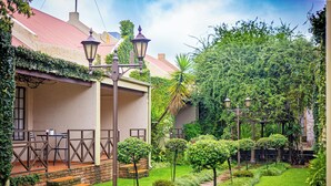 Un jardin avec une terrasse, des marches et un lampadaire.