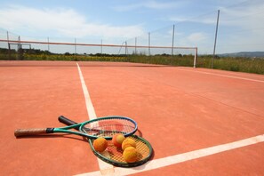 Un court de tennis avec deux raquettes de tennis et trois balles de tennis.