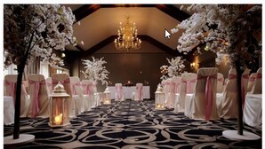 An indoor venue with a patterned carpet, chandeliers, and floral decorations. - Racket Hall Country House (Roscrea)