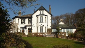 A large, white, two-story house with a prominent central entrance and a smaller attached structure. - Low Wood Hall Hotel (Seascale)