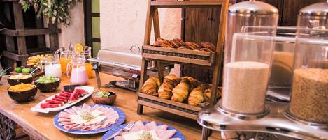 Un buffet de petit-déjeuner proposant divers aliments, avec une pancarte indiquant « Pain de Pan ».