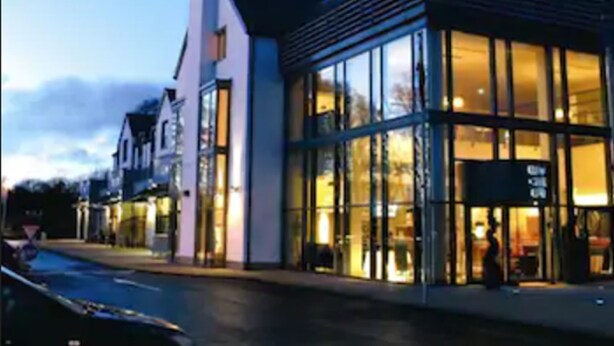 Un edificio moderno con grandes ventanales y una entrada destacada.