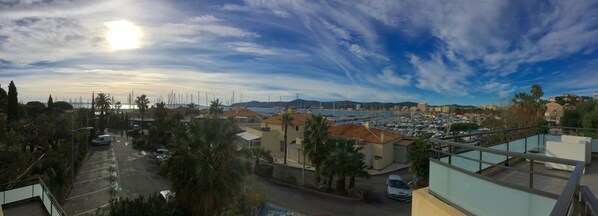 A coastal town with a marina, residential buildings, and a clear sky.