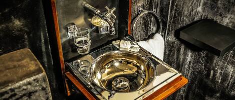 A vintage-style bathroom with a wooden vanity, a sink, and a mirror.