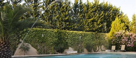 Een seizoensgebonden buitenzwembad en parasols bij het zwembad