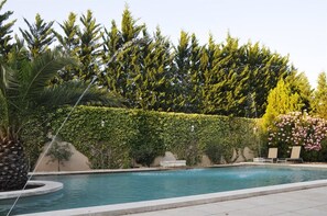 Een seizoensgebonden buitenzwembad en parasols bij het zwembad