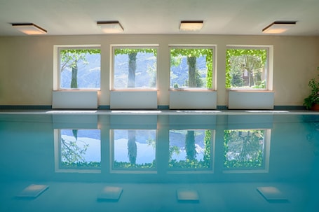 Una piscina techada, sillones reclinables de piscina