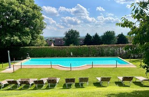 Una piscina al aire libre de temporada, sillones reclinables de piscina