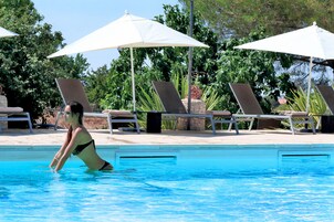 Una piscina al aire libre de temporada, sombrillas