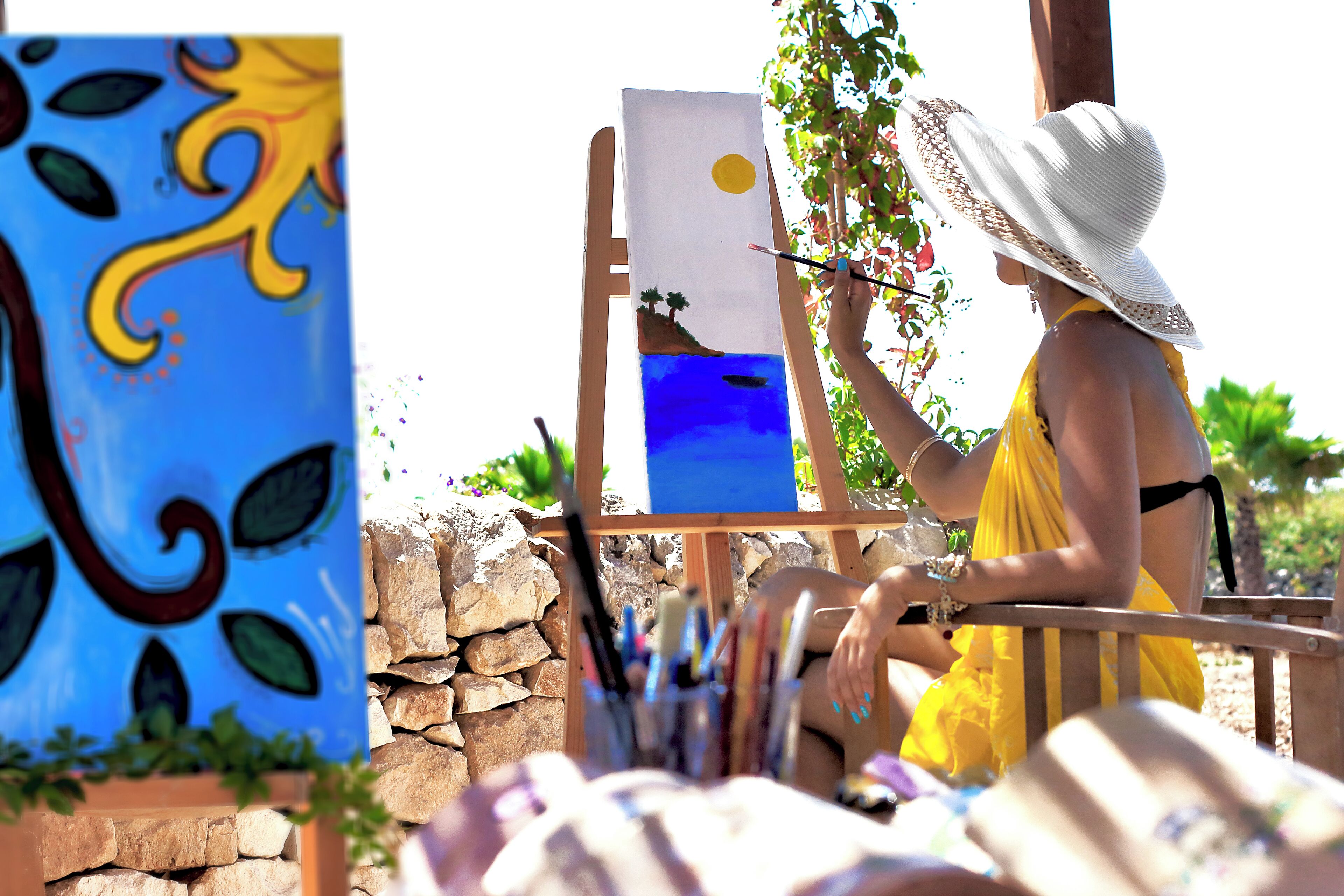 Un artista dipinge un paesaggio su un cavalletto all'aperto.