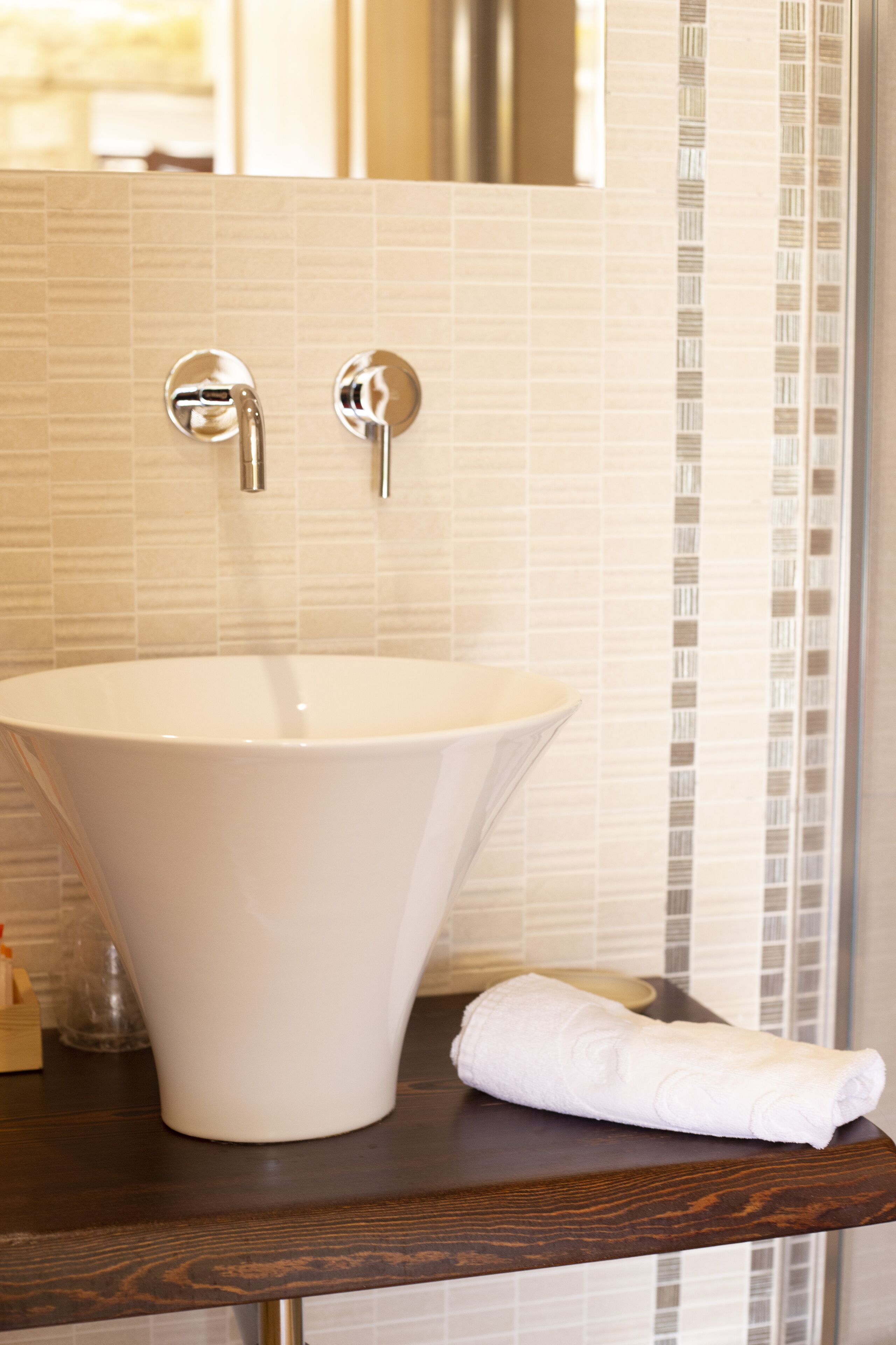 A bathroom with a white sink, a towel, and a mirror.