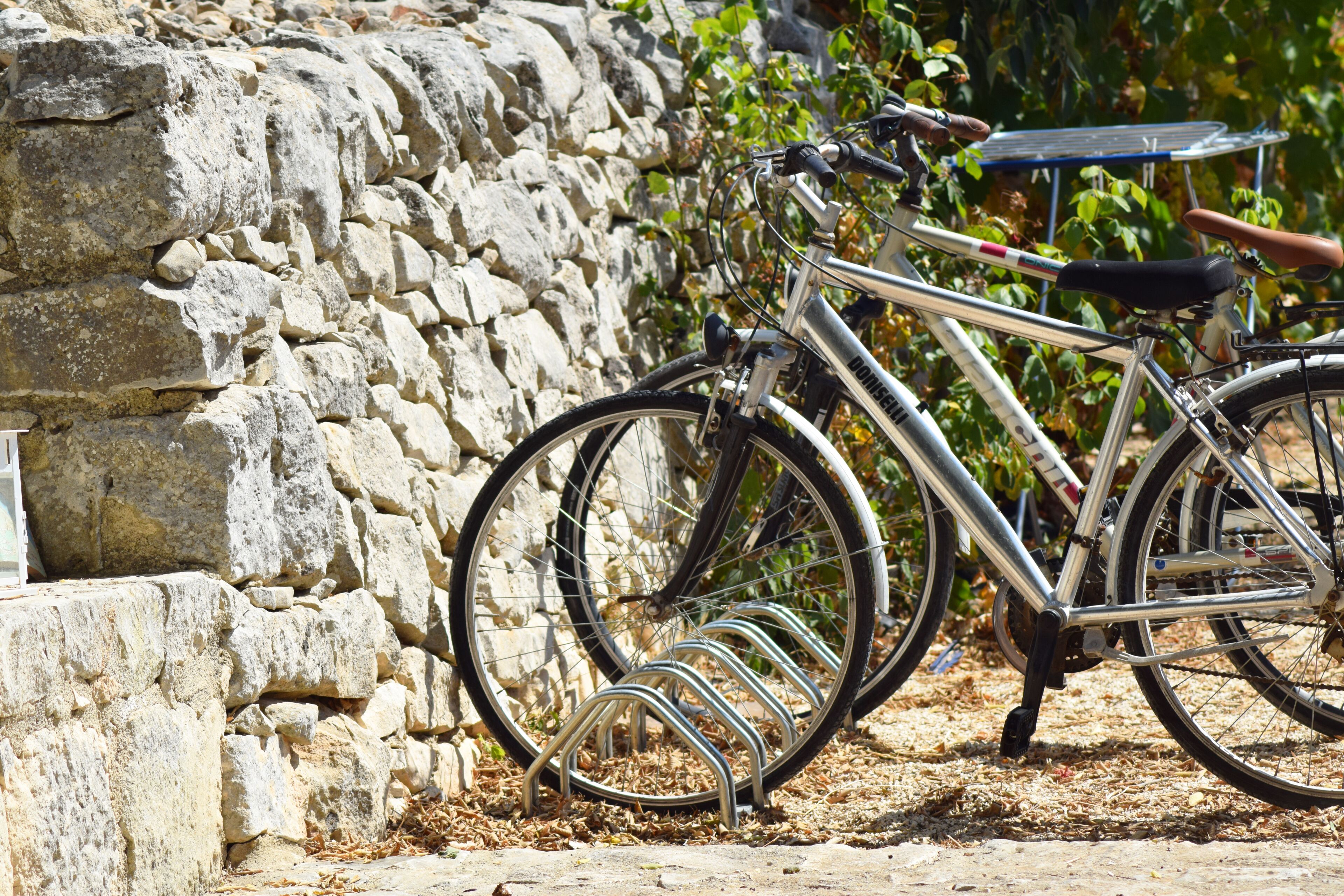 A bicycle parked next to a stone wall.