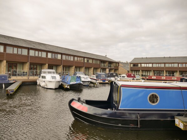 A marina with several boats docked in front of a building with multiple windows and balconies.
