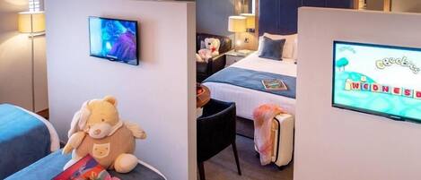 A hotel room with a TV, a bed, a desk, and a chair.