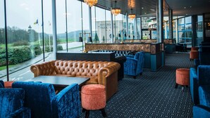 A modern restaurant with leather seating, blue chairs, and a patterned floor. - Riverside Park Hotel and Leisure Club (Enniscorthy)