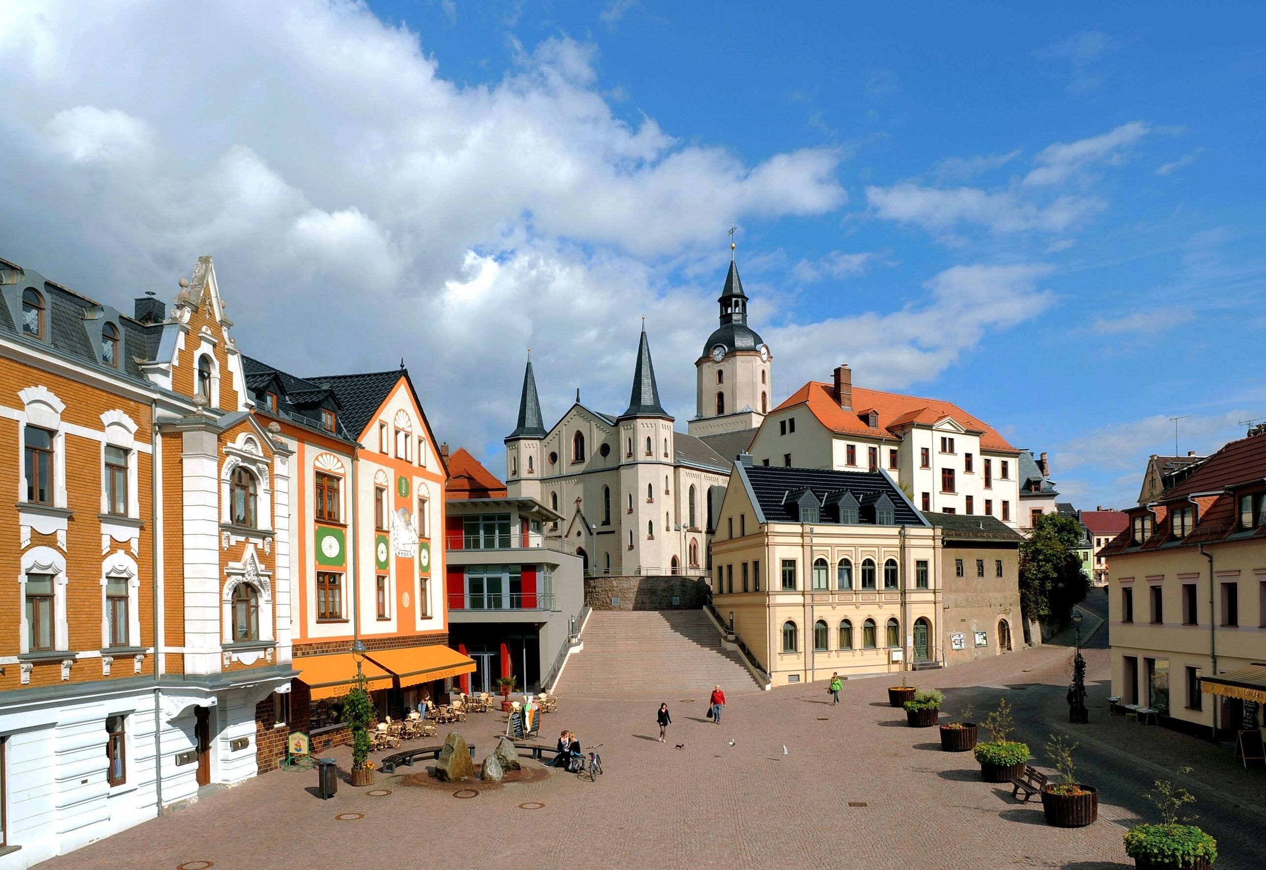 A historic town square with a prominent church, cobblestone streets, and traditional buildings.