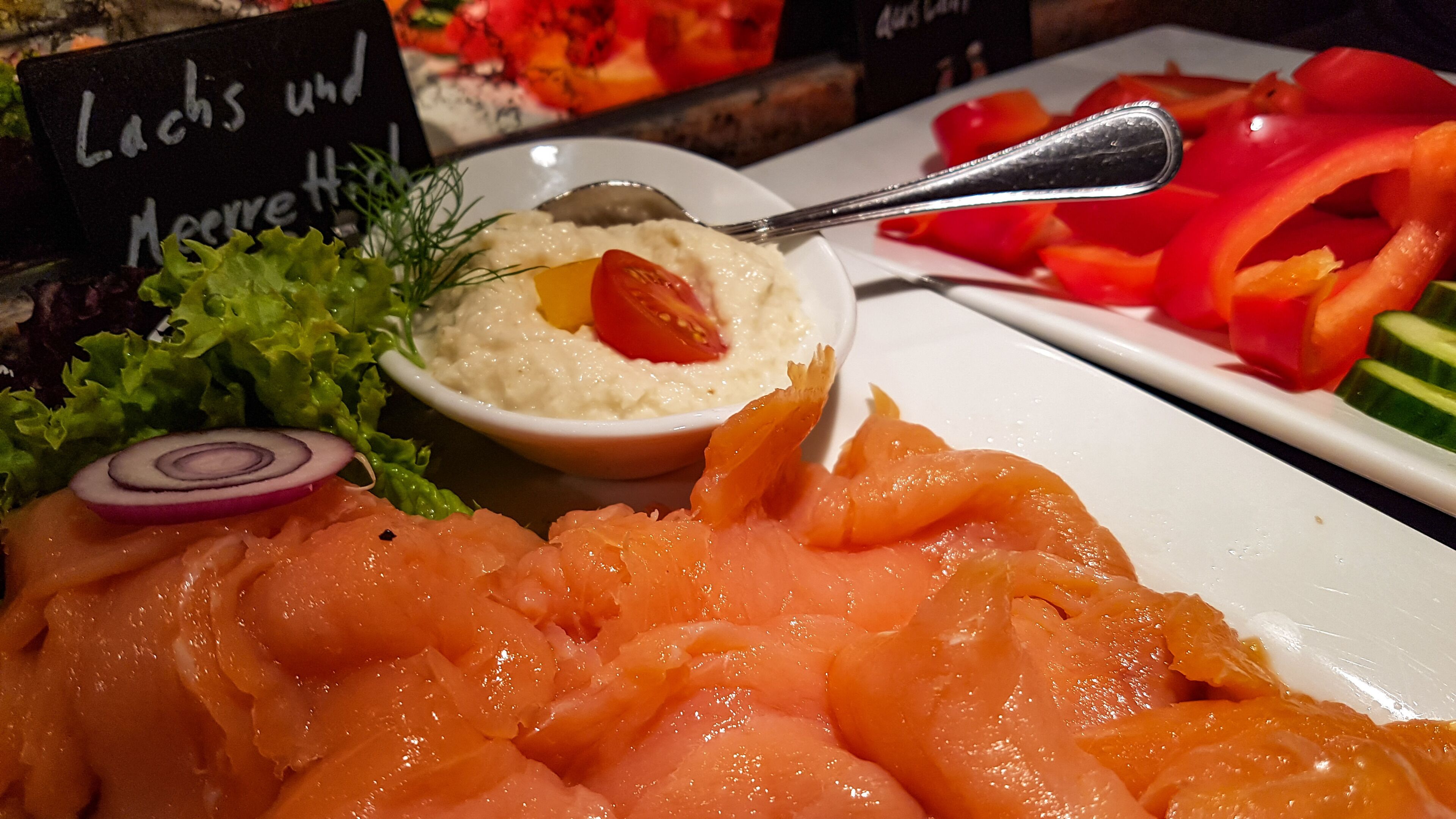 Un plato de salmón ahumado con una salsa cremosa y adornos.