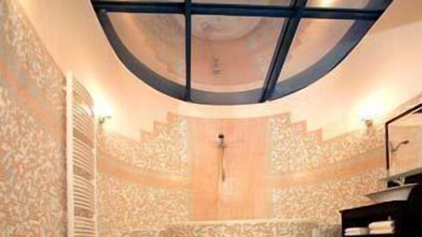 Un baño con diseño curvo, una bañera y una zona de ducha.