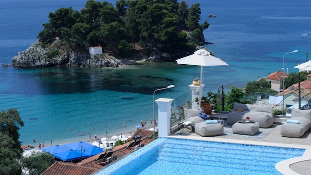 A poolside area with a view of the sea and a rocky island.