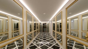 A hallway with mirrored doors and a geometric marble floor.