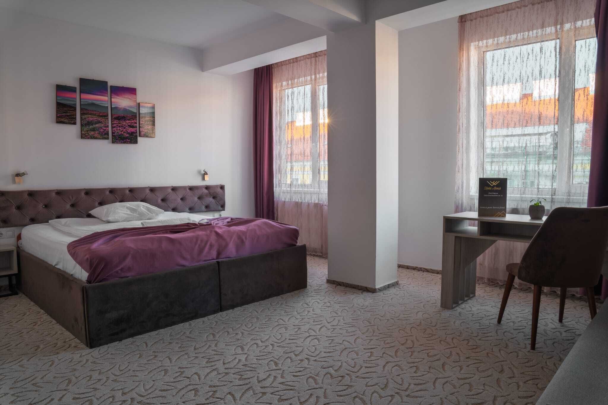 A bedroom with a bed, a desk, and a chair.