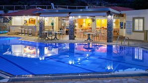 Una piscina con zona de bar y asientos al aire libre.