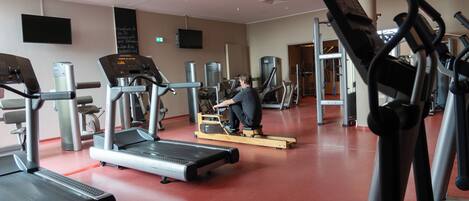 A gym with treadmills, elliptical machines, and weight equipment.